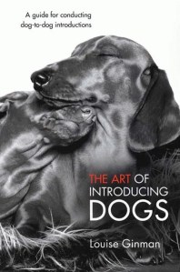book cover Two dogs relaxing together. Title: the Art of Introducing Dogs by Louise Ginman 
